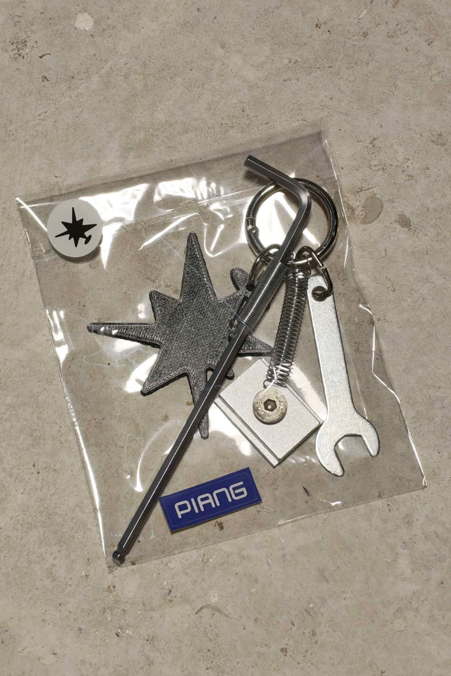 Keychain set with M6 allen key, M6 wrench, a T-nut and a 3D-printed logomark.