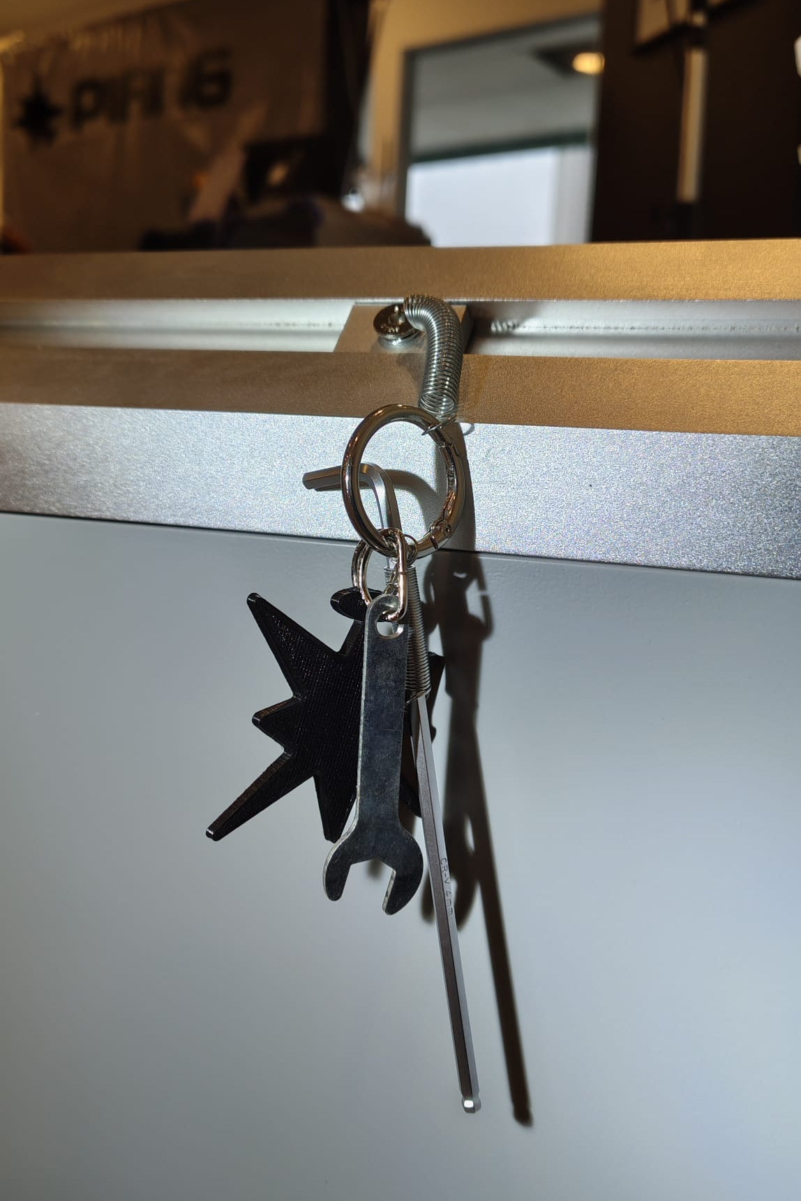Keychain set with M6 allen key, M6 wrench, a T-nut and a 3D-printed logomark.